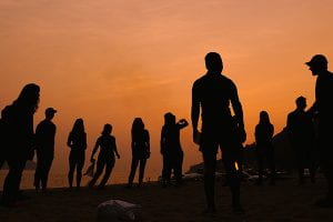 small group of people silhouetted against an orange sky